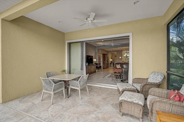 Step outside to the covered lanai, where decorative sculpted flooring, a ceiling fan, and mature landscaping create a private and inviting outdoor retreat.