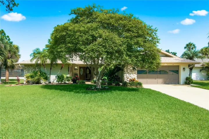 Charming front exterior featuring a lush, manicured lawn and mature shade trees welcoming you home.