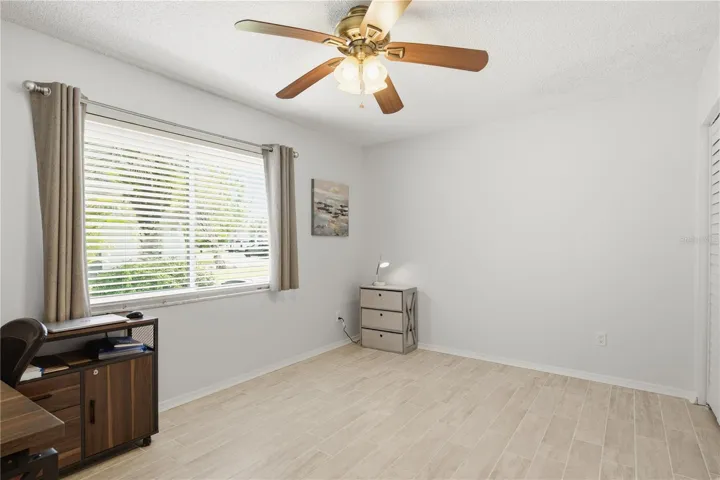 Versatile third bedroom, perfect for a home office or guest room with a large hurricane proof window bringing in natural light.