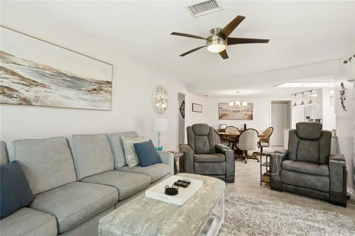 Another view of the spacious living room showcasing the open concept layout that flows seamlessly toward the kitchen and secondary seating area.