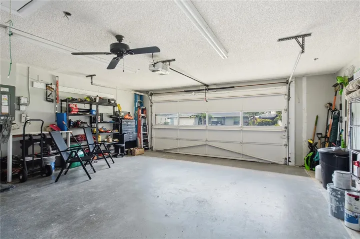 2 car garage equipped with an automatic door opener, overhead ceiling fan, and plenty of room for storage or a workshop.