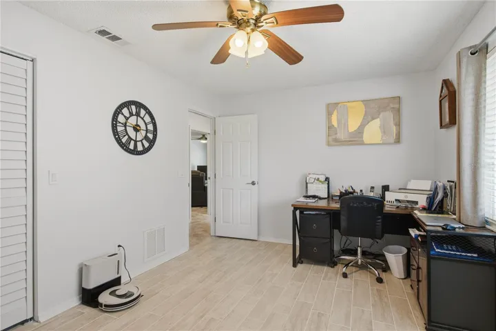 Alternate angle of the third bedroom showing a large double closet to the left and an entry door leading back to the main hallway.