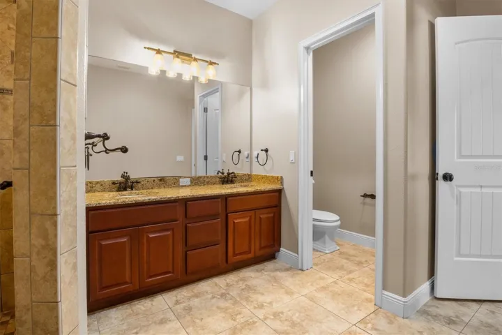 Primary bathroom, tile shower, multi-shower heads including rain, dual vanity granite sinks, storage closest