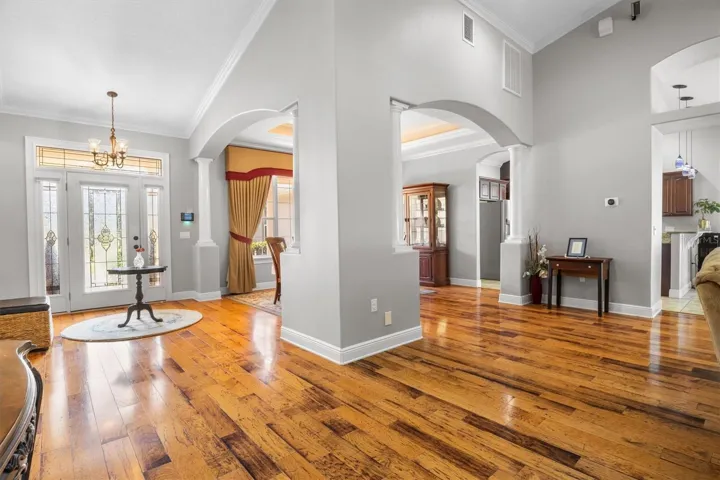 Entryway, wood flooring, open floor plan leading to dining room and living room