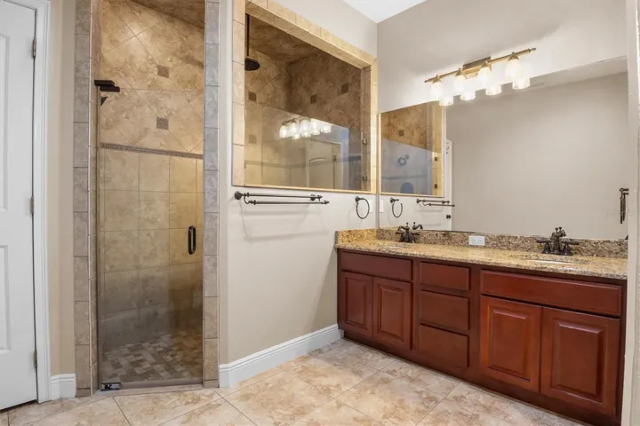 Primary bathroom, tile shower, multi-shower heads including rain, dual vanity granite sinks, storage closest