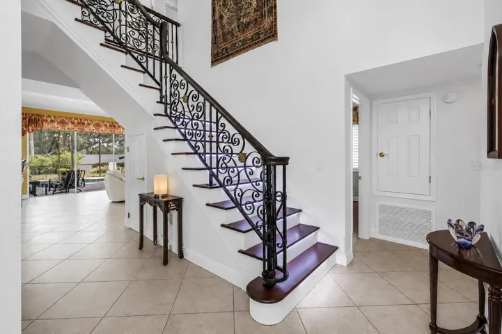 Foyer & Staircase with Custom Wrought-Iron Railing and Stair-Tread Lighting