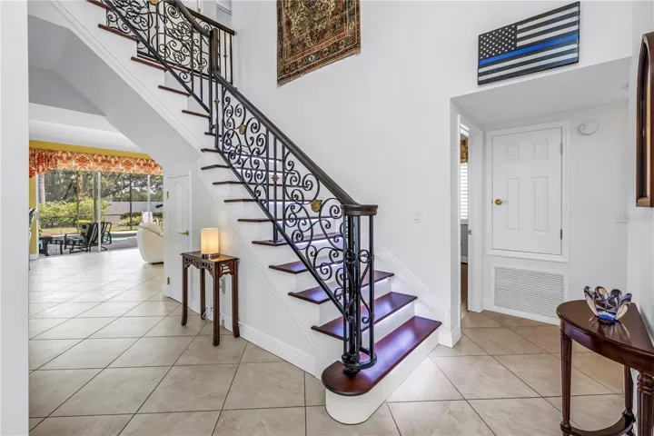 Foyer & Staircase with Custom Wrought-Iron Railing and Stair-Tread Lighting