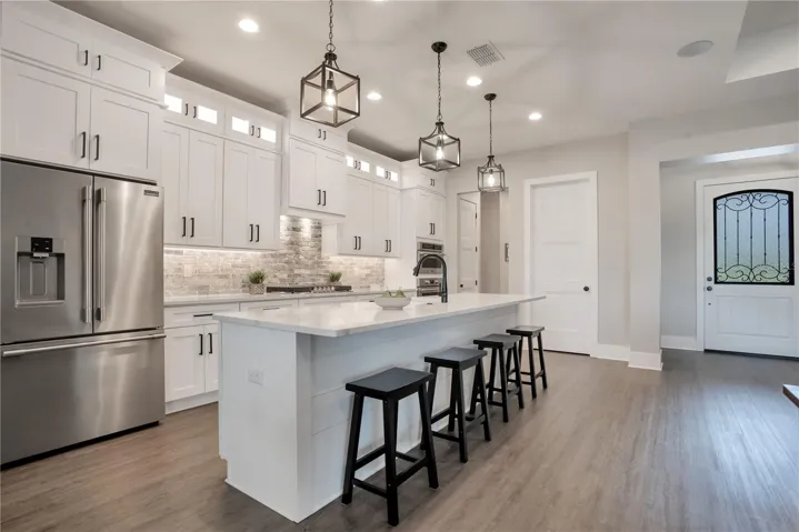 Bright and spacious gourmet kitchen with oversized island seating, stainless steel appliances, and premium finishes throughout.