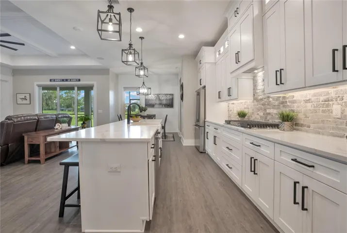 Designer kitchen featuring quartz countertops, custom cabinetry, under-cabinet lighting, and an open layout ideal for entertaining and everyday living.