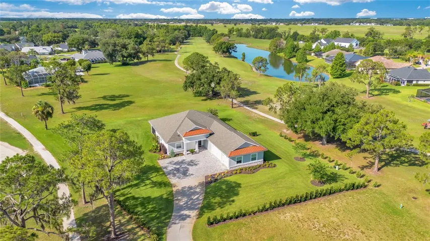 Aerial view showcasing one of the largest homesites in Cypresswood Golf & Country Club, offering privacy, open green space, and panoramic golf course views.
