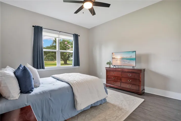 Spacious secondary bedroom with large window, neutral finishes, and flexible use for family, guests, or multigenerational living.