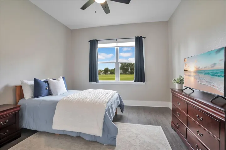 Spacious secondary bedroom with abundant natural light, generous closet space, and peaceful views of the surrounding community.