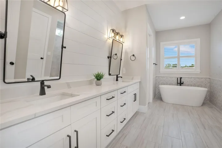 Spa-inspired primary bathroom with dual vanities, soaking tub, walk-in shower, and elegant finishes designed for comfort and relaxation.