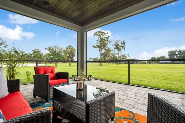Expansive screened patio providing seamless indoor-outdoor living and peaceful views across the oversized one-acre homesite.