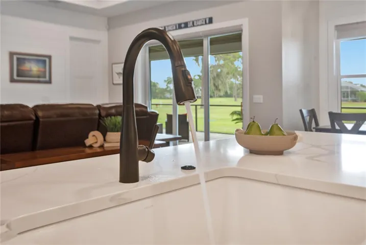 Kitchen sink overlooking the living areas and golf course views, enhancing the home's open and connected design.