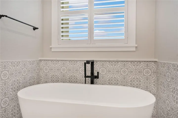 Freestanding soaking tub creates a spa-inspired retreat within the elegant primary bathroom, perfect for relaxation and comfort.