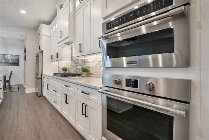 Built-in wall oven and microwave complement this thoughtfully designed chef's kitchen featuring abundant storage and workspace.