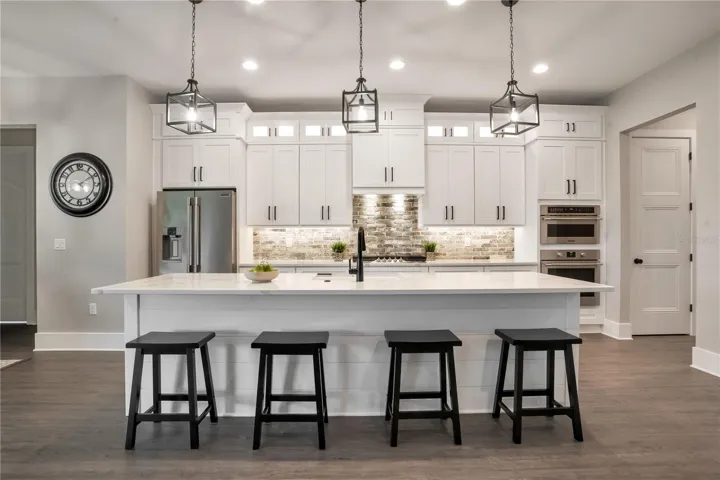 Expansive chef's kitchen with oversized quartz island, custom cabinetry, designer lighting, and open-concept entertaining space.