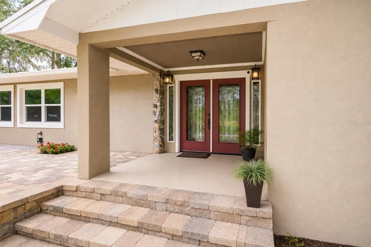 Welcoming front entrance featuring decorative pavers and a glass front door.
