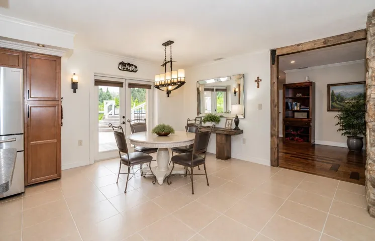 Bright dining room featuring French doors with easy access to the pool.
