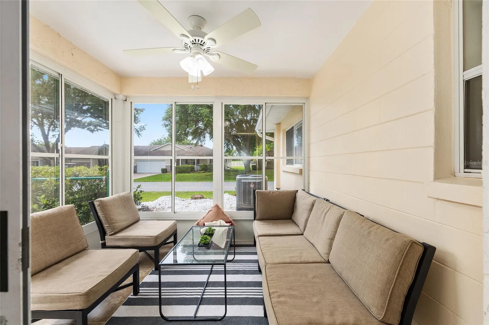 Sliding glass doors lead to a vinyl-enclosed lanai, perfect for enjoying morning coffee, relaxing afternoons, or additional indoor/outdoor living space
