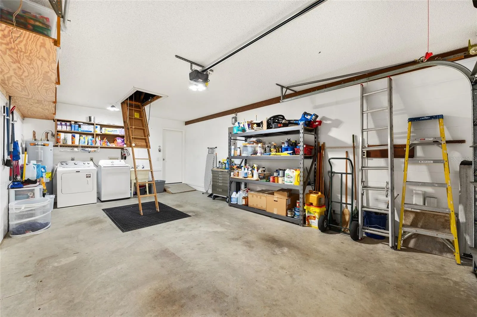 1.5-car garage includes washer and dryer, plenty of storage space, and a drop-down attic ladder for additional storage.