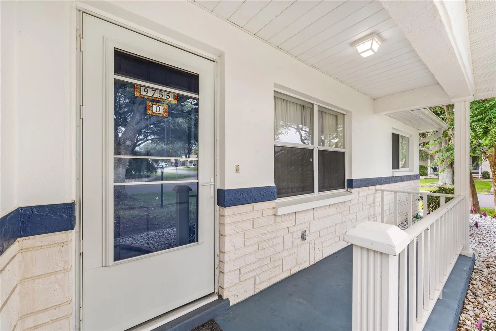 Front porch offers a peaceful spot to relax and enjoy the beautiful shade trees.