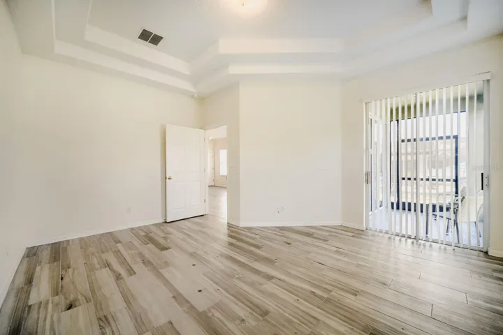 Spacious Primary Bedroom with tray ceiling and patio access