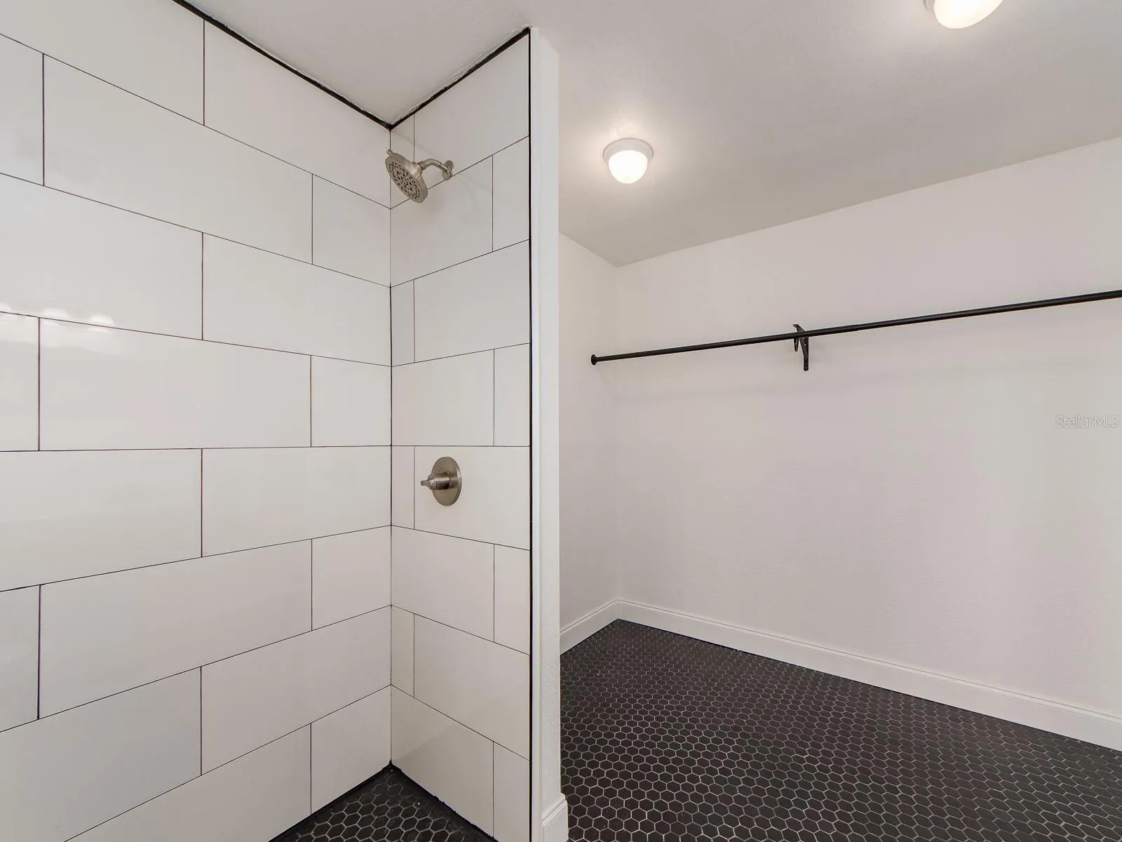 walk in shower with closet space in the back of the bath.