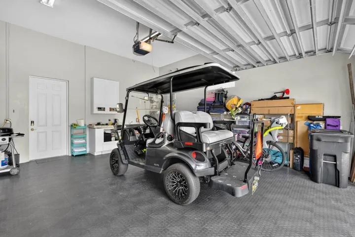 Two car garage with golf cart included.  Cabinets, mud sink, refrigerator