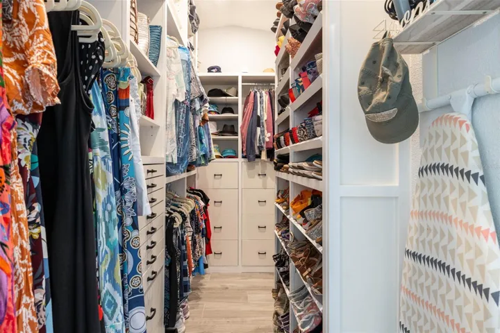 Custom closet organizer runs floor to ceiling to maximize storage options.