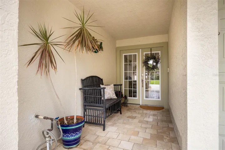 Main Entrance with lovely covered patio finished with travertine.