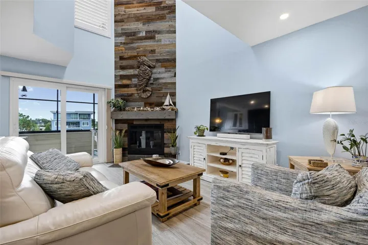 Main floor Living Room with vaulted ceiling and impressive fireplace with wood accent wall.