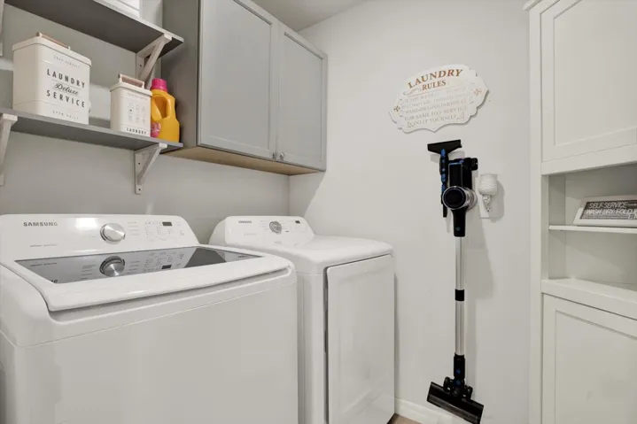 Laundry room includes washer, dryer and custom cabinets