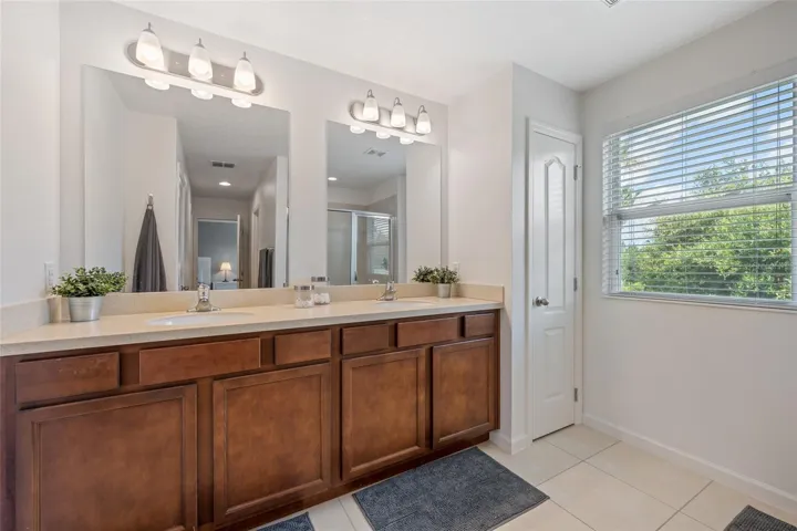 Primary Bathroom with Dual Sinks, Linen Closet and Window