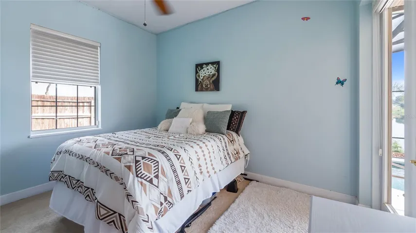 Bedroom 2, doorway to hall/guest bathroom and double glass doors to rear patio and pool
