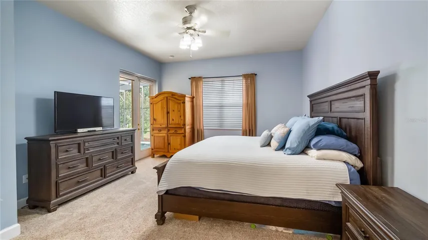 Primary bedroom with double glass doors out to rear patio/pool