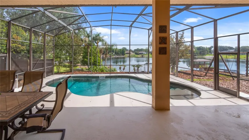 View stepping out of great room to rear patio/pool and lake Katherine