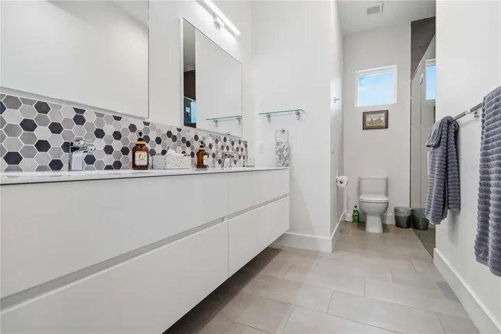 Primary En Suite Bathroom with Dual Sinks and Walk-In Shower plus a ceiling fan
