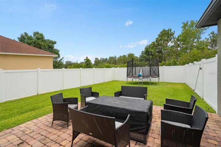 custom paver patio and view of backyard