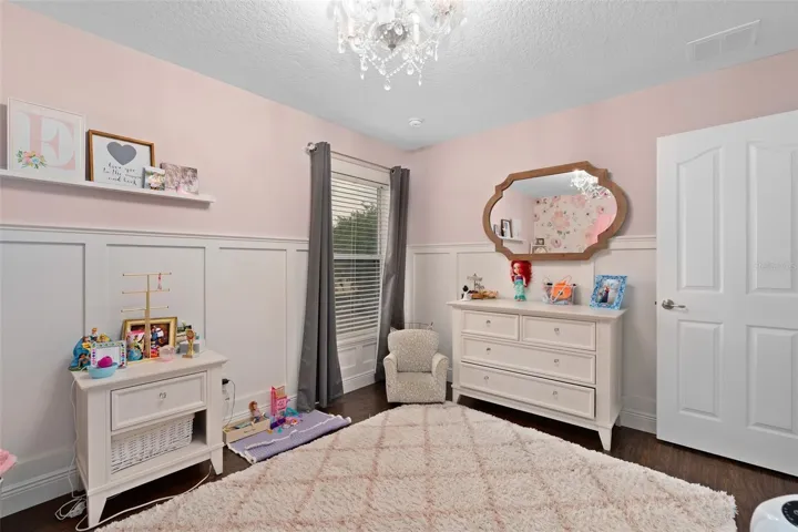 bedroom 4 upstairs with custom wainescoating and laminate flooring.