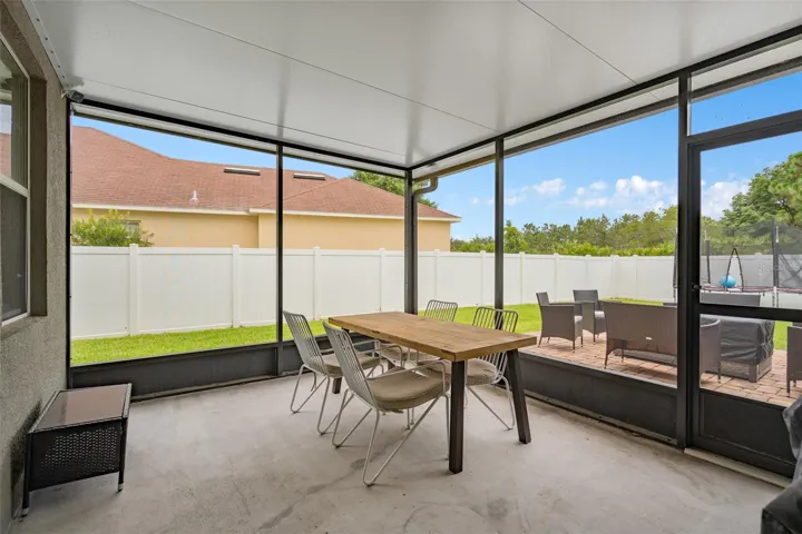 rear covered/screened patio overlooking white 6 ft pvc privacy fencing around rear yard
