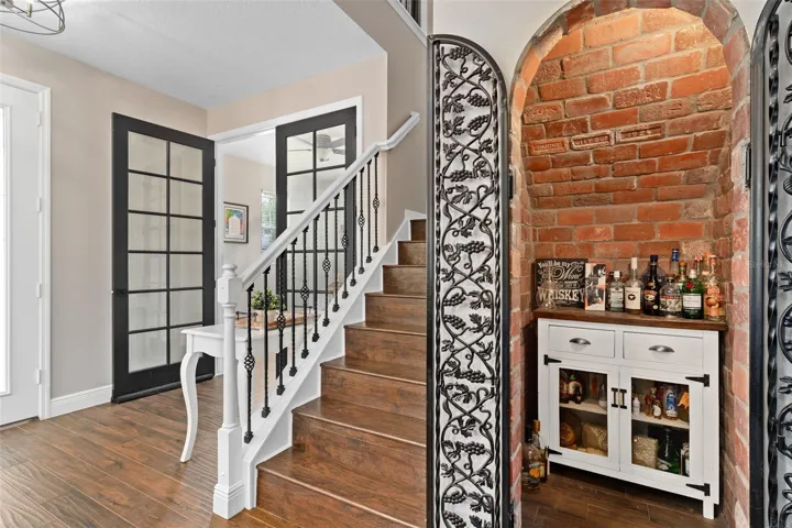 custom brick lined wine room with wrought iron doors.