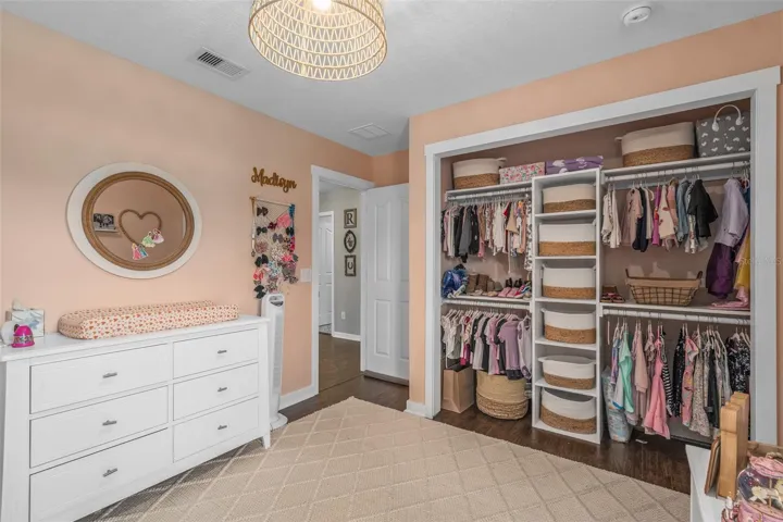 bedroom 3 upstairs with custom accent wall and laminate flooring and custom built closet