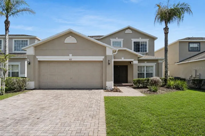 Beautifully maintained 5-bedroom, 4-bath pool home featuring attractive curb appeal, mature landscaping, and a paver driveway within the gated community of Highgate Park.