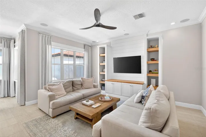 Living room with integrated speakers and custom wood built-in shelving