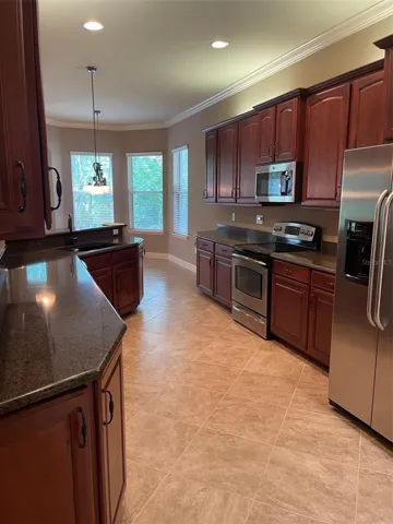 KITCHEN WITH GRANITE COUNTERS, STAINLESS APPLIANCES AND WOOD CABINETS