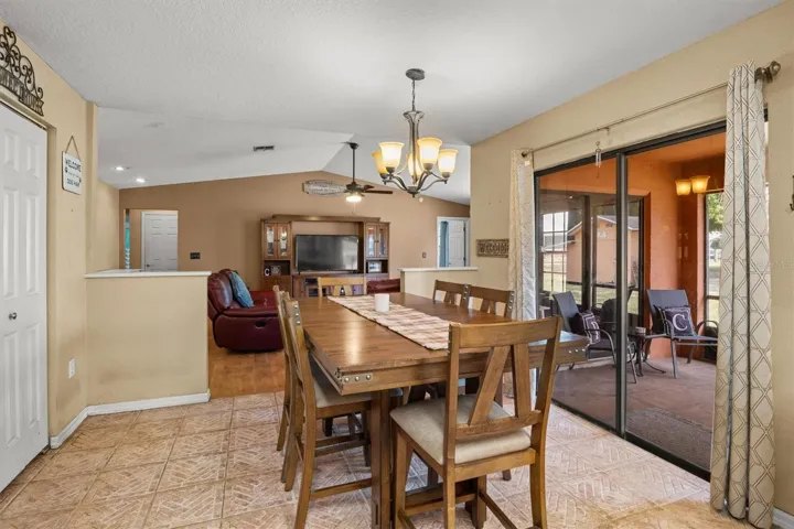 dining room view towards living room. Sliding doors lead to back patio. There is a door on the left from the dining room that leads to the garage