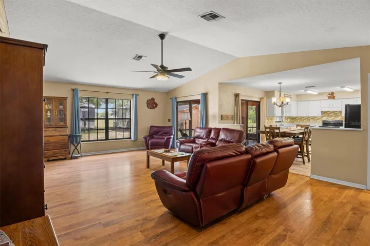 living room view towards kitchen. Sliding doors lead to back patio from living room and the dining area.