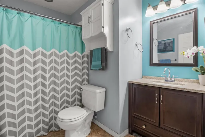 Hallway bathroom with tub/shower combo. single vanity with granite countertop